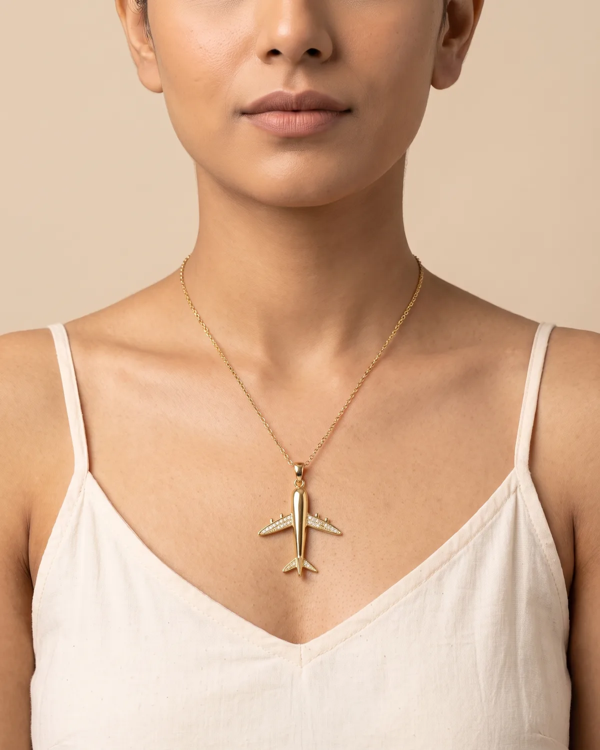Wanderlust Drop: The design plays on clean, aerodynamic lines, rendering a miniature airplane in a warm, polished golden hue.